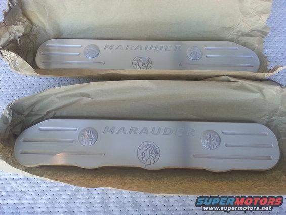 Two aluminum Marauder branded coil covers, one on top of the other, wrapped in paper