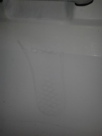 Faint tire tread imprint on a white surface
