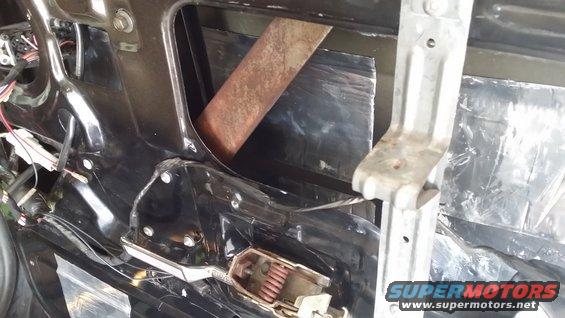 inside of a car door, showing window mechanism and soundproofing material