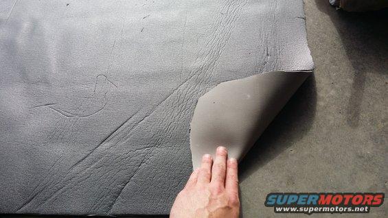 hand peeling back sound deadening material from floor