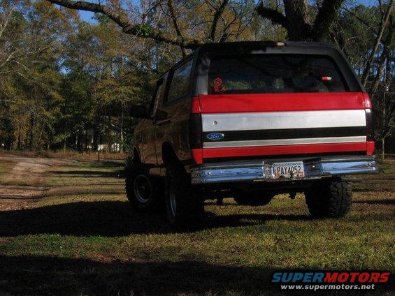 1992 Ford Bronco rear view, lifted, with red, silver, and black stripe on tailgate