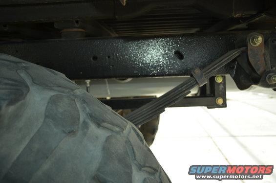 Close-up of leaf spring suspension and large tire tread