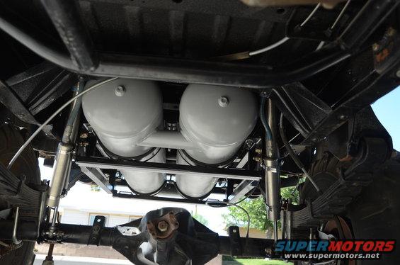 Undercarriage view of four air tanks mounted on a vehicle frame