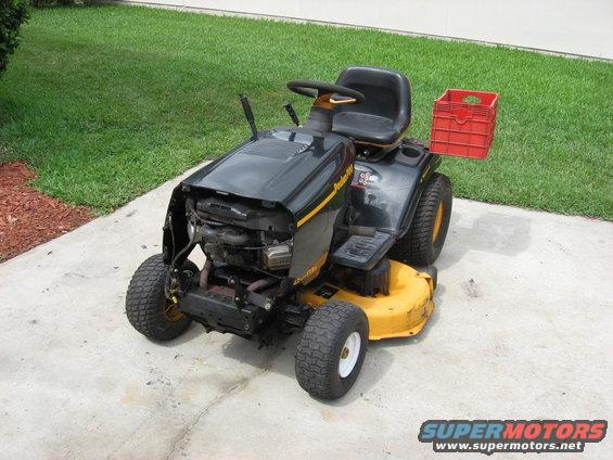 Black and yellow riding lawn mower with a red crate on the back