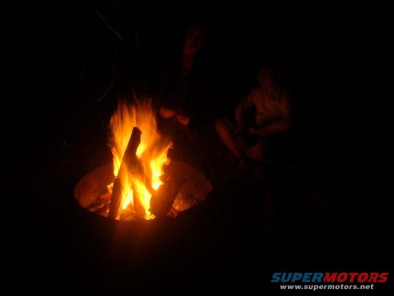 Campfire with two people sitting in the dark