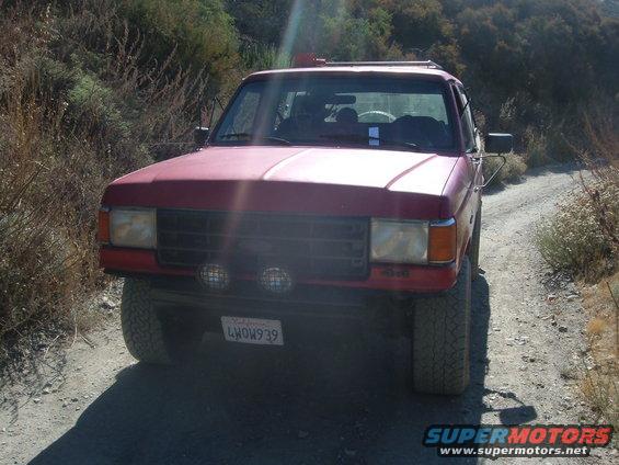 Red 1988 Ford Bronco front view on dirt road