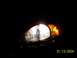 2003 Ford Taurus - The illuminated headlight assembly of a 2003 Ford Taurus is visible against a dark background.