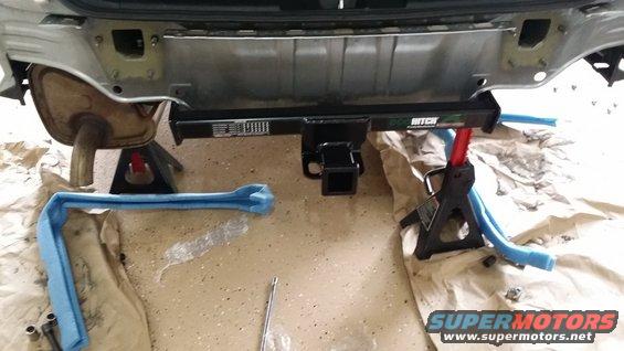 Hitch receiver installed on rear bumper, supported by jack stands