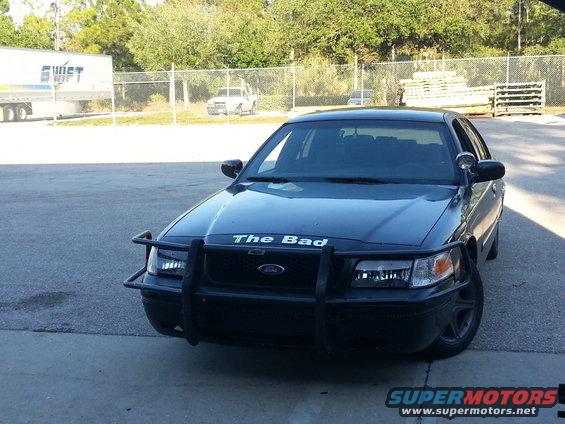 Black Ford Crown Victoria with a push bar and "The Bad" text on the hood