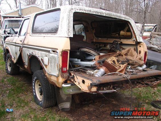 1978 Ford Bronco rear view, open cargo door filled with debris, rust damage