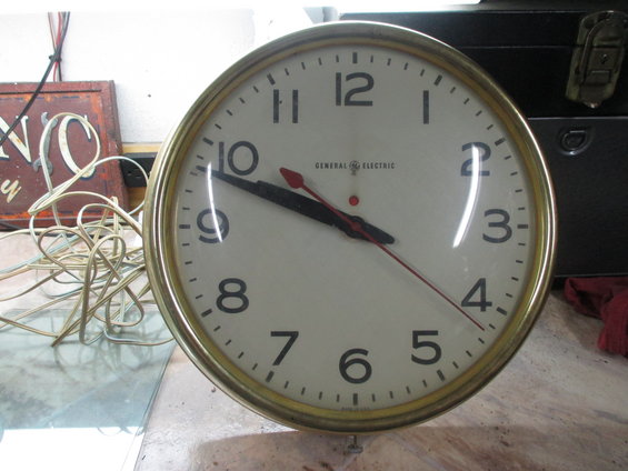 GE electric clock with black hands and red second hand, brass bezel