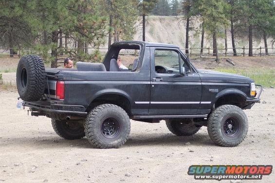 Black 1990 Ford Bronco with spare tire on rear, lifted suspension, and off-road tires