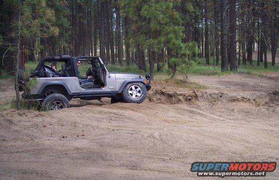Silver 2005 Jeep Wrangler driving on dirt trail