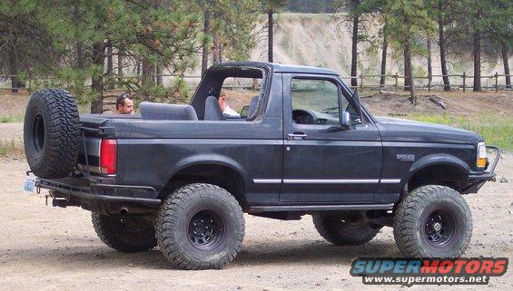Black Ford Bronco with spare tire on rear, lifted suspension, and off-road tires