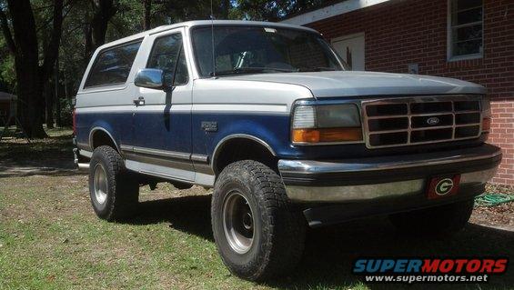 1996 Ford Bronco parked on grass in front of a brick house