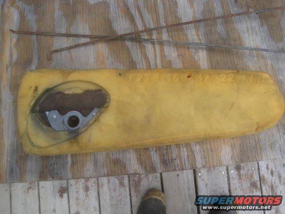 Yellow foam part with metal mechanism and rusty wires, text 'F2TB 19G44 AA 22A' visible