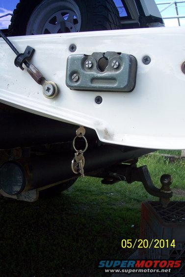 Rear tailgate latch mechanism with keys hanging from it, plus a trailer hitch receiver
