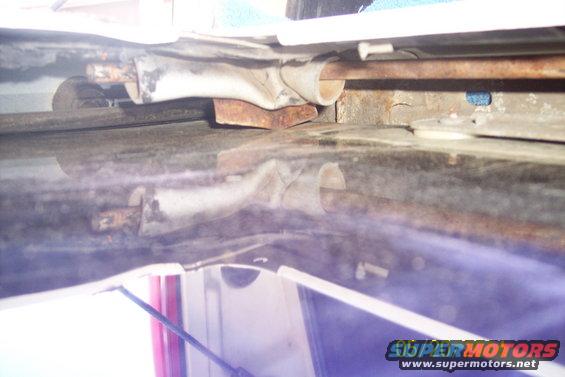 Rusty tailgate torsion bar mechanism with metal brackets and rods