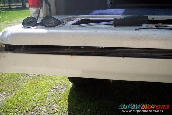 White tailgate torsion bar mechanism with sunglasses and screwdriver on top. 1990 Ford Bronco