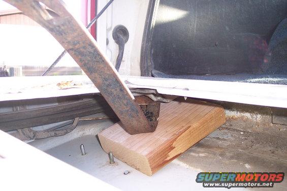 Tailgate torsion bar mechanism with wooden support inside a vehicle's cargo area