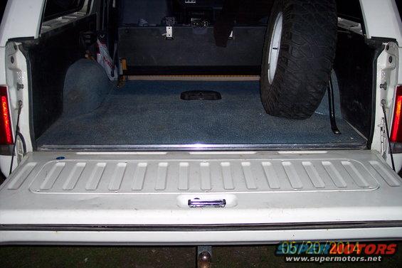 tailgate open showing carpeted cargo area with spare tire mounted