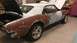 1973 Chevrolet Camaro - Camaro in body shop, showing primer and rust. Trunk and hood are open.