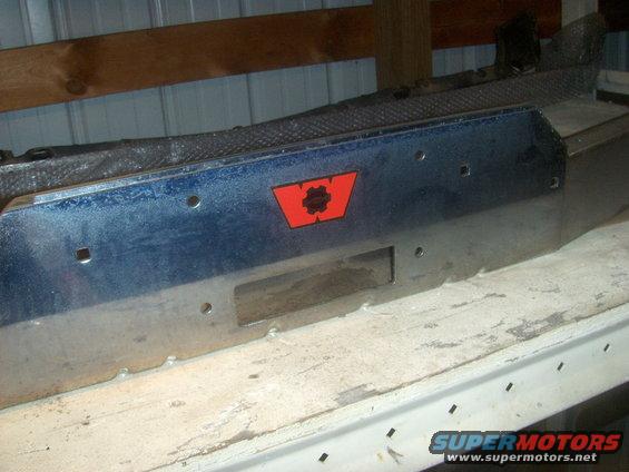 Front view of a metal winch bumper with a red and black logo