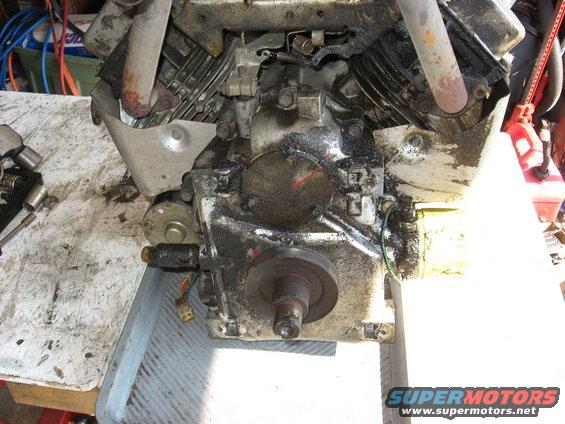 Close-up of a greasy engine block with a pulley attached