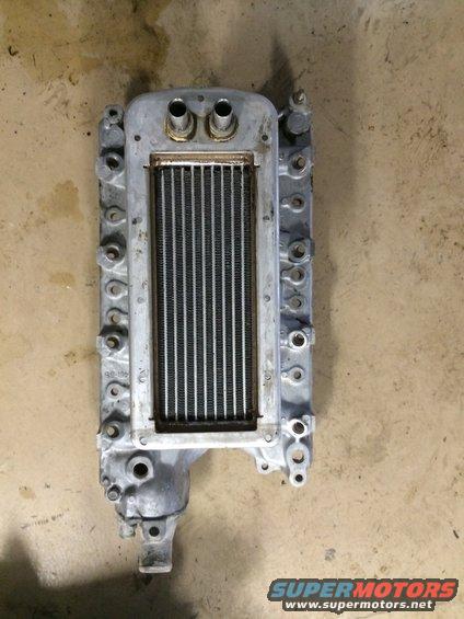 Aluminum supercharger intercooler with dual inlet/outlet ports and a finned radiator core