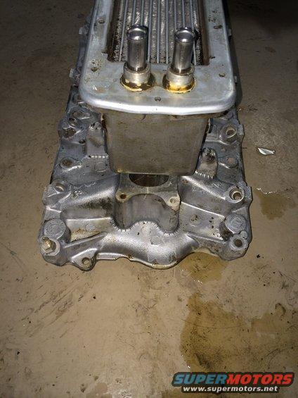 Supercharger part with two metal tubes and a silver casing