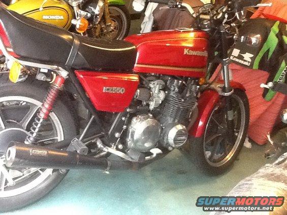 Red Kawasaki KZ550 motorcycle side view. Other motorcycles visible