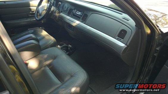 Black leather seats and dashboard of a 2003 Ford Crown Victoria, viewed from the passenger side door