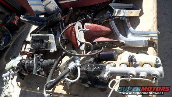 Assorted car parts including brake master cylinder, fuse box, and chrome trim
