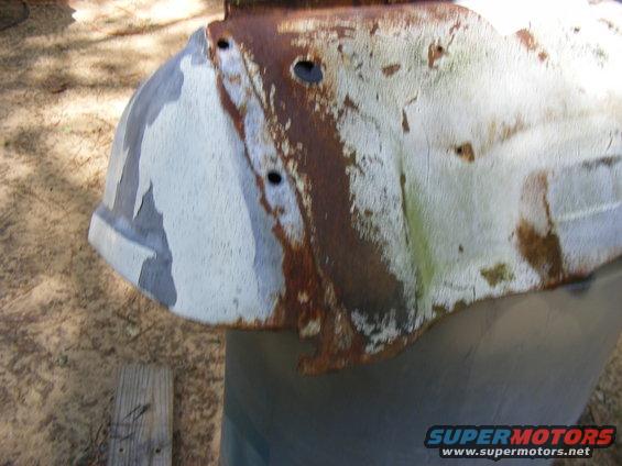 rusted metal panel with peeling paint, possibly from a vehicle