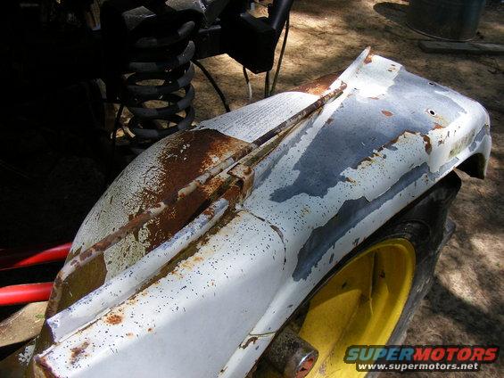 Rusted white fender and yellow wheel