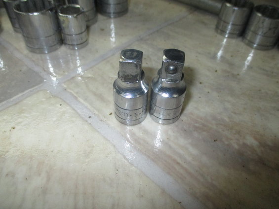 Two chrome socket adapters with readable text on their sides