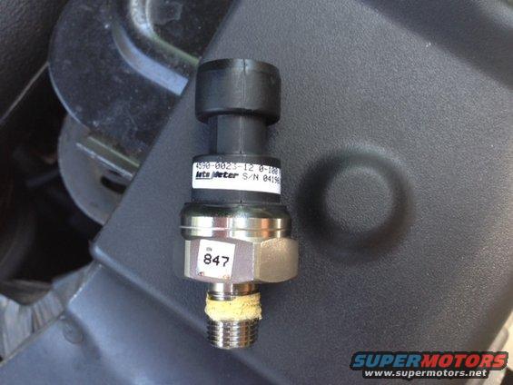 Close-up of an automotive sensor with part number 4590-0023-12 and serial number S/N 04196