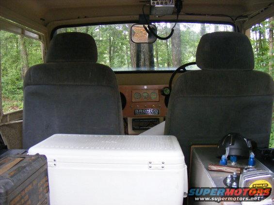 Interior view of a 1978 Ford Bronco with a cooler and dashboard gauges