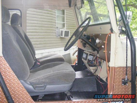 Vehicle interior with gray cloth seats, diamond plate trim, and a black steering wheel