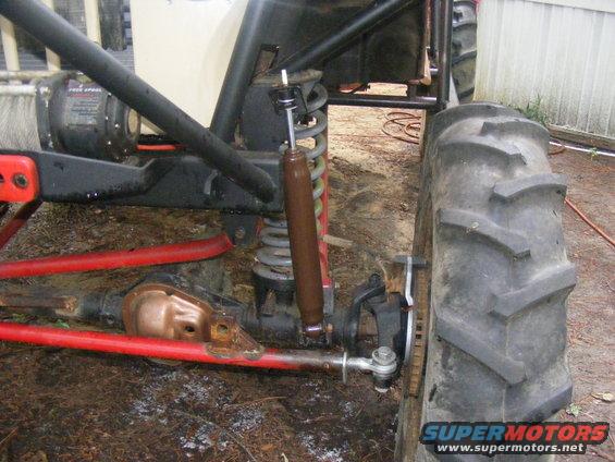 Close-up of a buggy's suspension system with large tires and a winch visible