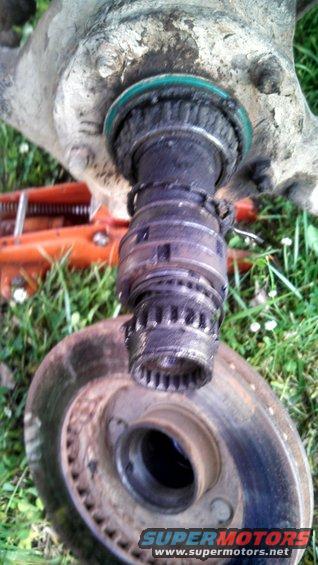Close-up of a disassembled wheel hub assembly with a brake rotor in the foreground