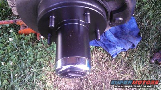 Wheel hub with chrome trim and five lug nuts, part of a vehicle repair