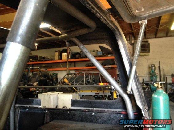 Roll cage inside a vehicle, with shelves and other vehicles in the background