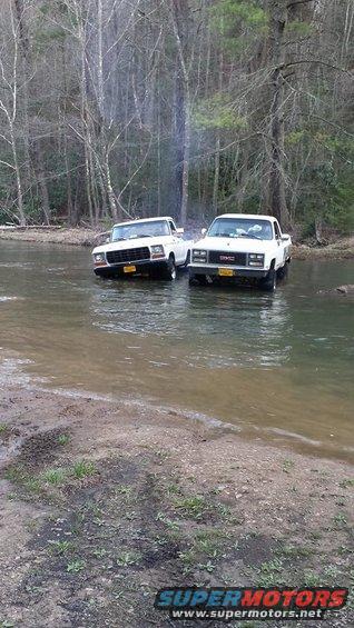 1979 Ford F-150 and 1970s GMC pickup truck crossing a river
