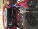 1978 Ford Bronco - The interior of a vehicle is being worked on, with red paint visible and parts covered in black plastic.
