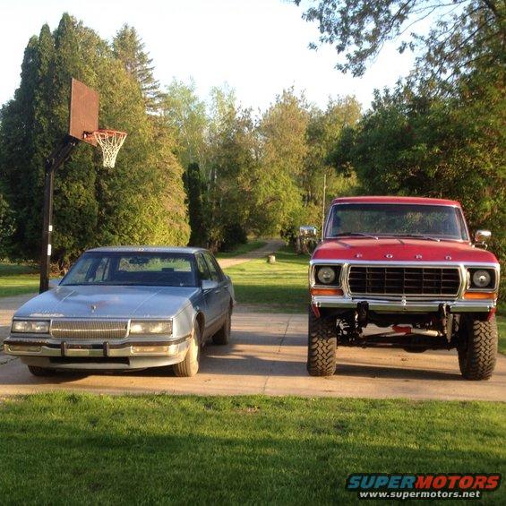 Red 1978 Ford F-Series pickup truck parked next to a blue sedan
