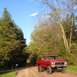 1978 Ford Bronco - A red 1978 Ford F-150 pickup truck is parked on a dirt road surrounded by trees.