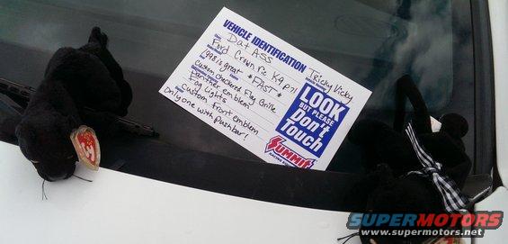 Vehicle identification note on windshield with 'LOOK BUT PLEASE DON'T TOUCH' sticker and plush panthers
