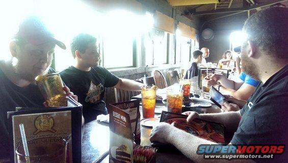 People seated at tables in a restaurant with drinks and menus