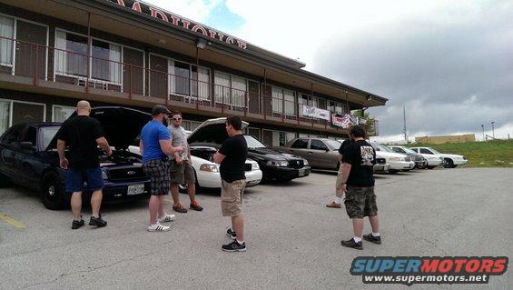 Dark blue Ford Crown Victoria with hood open, parked in front of a motel